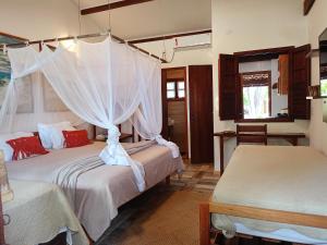 a bedroom with two beds with mosquito nets at Vila Bello Pontal in Coruripe +102 photos