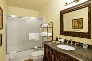 a bathroom with a sink and a toilet and a mirror at Buttercup Snow Summit Condo by Big Bear Vacations in Big Bear Lake +9 photos