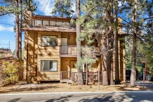 a house with a balcony and trees in front at Buttercup Snow Summit Condo by Big Bear Vacations in Big Bear Lake