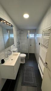 a white bathroom with a sink and a toilet at Moderne Industriewohnung in Everswinkel