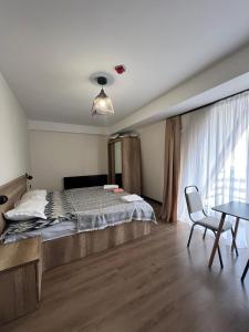 a bedroom with a large bed and a table at Nirvana Stayz Gudauri in Gudauri