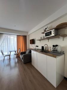 a kitchen and living room with a couch and a table at Nirvana Stayz Gudauri in Gudauri