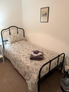 - une chambre dotée d'un lit avec un cadre noir dans l'établissement Single room with beautiful garden, à Édimbourg