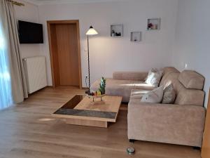 a living room with a couch and a coffee table at Ferienwohnung mit Küche & kleines Gästezimmer Lisi ohne Küche im Obergeschoß - 2 separate Einheiten - nahe Salzburg, ideal für Familien & Durchreise in Kuchl