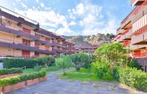 an apartment complex with a courtyard with bushes and trees at Sulla spiaggia di Letojanni in Letojanni