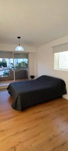 a bedroom with a large bed and a large window at Departamento Barrio Martin in Rosario