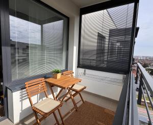 ein Balkon mit zwei Stühlen und einem Tisch und einem Fenster in der Unterkunft Apt 555 New & Fully Equipped with Free Garage in Bratislava + 36 Fotos