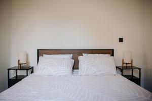 a bed with white pillows and two night stands at Chez Lilie in Le Sel +19 photos