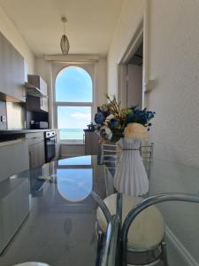 a kitchen with a glass table with a vase of flowers at Farina No7, Sea view studio sleeping 2 guests in Bridlington
