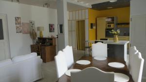 a living room with a table and white chairs at Bienvenue dans le 56 in Chauffailles