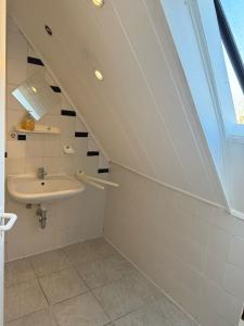 un baño en el ático con lavabo y lavabo en Privates Zimmer Gemeinschaftsbad keine Küchen, en Núremberg