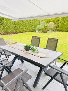 a picnic table with chairs on a patio at The Villa Toscana, a serene retreat in Center of Friedrichshafen City with lush green lawns, terrace & private garage- Lidl, Bakery walking distance- Bodenseecenter, Sportsbad 3 mins, Lake 7 mins in Friedrichshafen +26 photos