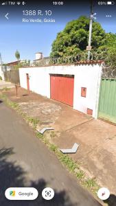 a white building with a red door on the side of a street at Tecnoshow 2025 - casa in Rio Verde