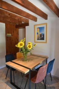 a dining room table with a vase of sunflowers on it at Lou Cigalou - Au Calme - Grand Jardin - Piscine Partagée - Parking - Campagne et Idéalement Situé Proche A7 et Montélimar in Sauzet +71 photos