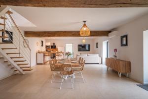 a dining room and living room with a table and chairs at La Grange Clyna - Love Room in Parigné-lʼÉvêque