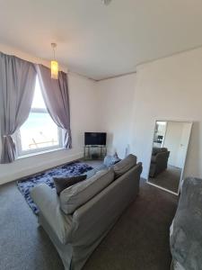 a living room with a couch and a large window at Farina No7, Sea view studio sleeping 2 guests in Bridlington