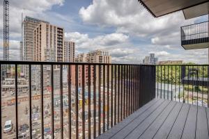 a balcony with a view of a city with tall buildings at Modern, Spacious 2bed, 2bath apartment in Barking in Barking