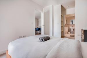 a bedroom with a large white bed with a pillow on it at Modern, Spacious 2bed, 2bath apartment in Barking in Barking