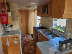 a small kitchen with a sink and a stove at Ingoldmells golden sands plot 152 in Ingoldmells +6 photos