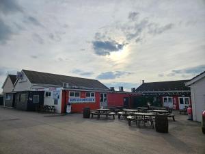a group of picnic tables in front of a building at Ingoldmells golden sands plot 152 in Ingoldmells
