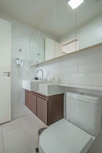 a bathroom with a toilet and a sink and a mirror at Studio 517 com Garagem - Perto do Consulado e Autódromo de Interlagos in Sao Paulo