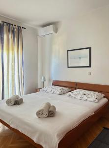 a bedroom with a bed with towels on it at Holiday Home Villa Emma in Debeljak