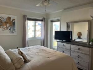 マートルビーチにあるSalt Lifeのベッドルーム1室(ベッド1台、ドレッサー、テレビ付)