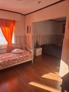 a bedroom with a bed with an orange curtain at Cottage Viardo in Vehkataipale