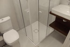 a bathroom with a toilet and a glass shower at Suíte Santa Catarina in Pomerode