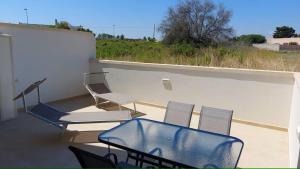 a patio with chairs and tables on a balcony at Casa PERLAMARE in Otranto