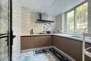 a kitchen with brown cabinets and a sink and a window at Nicer Family in Leshan