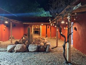 a building with a yard with rocks and a tree at La Genoveva Posada entre Viñedos in Villa Unión