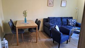 a living room with a table and a blue couch at Ferìenwohnung Mende 2 in Lübbenau +4 photos