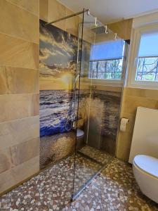 a bathroom with a shower with a painting of the ocean at Marburg Apartment feuriger Felix mit Kamin und Garten in ruhiger Waldrandlage in Marburg an der Lahn +9 photos