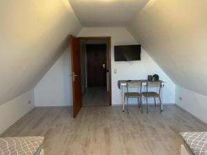 a room with a table and a television in a attic at Relax in Wilster +9 photos