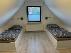 two beds in a room with a window at Relax in Wilster