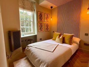 Un dormitorio con una cama grande y una ventana. en The Georgian Ace, central two bed two bath,Bath Keys, en Bath