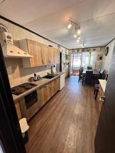 a large kitchen with wooden floors and a dining room at Cottage Viardo in Vehkataipale
