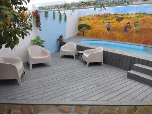 a swimming pool with chairs and a painting on the wall at Casa do Pão in Campinho