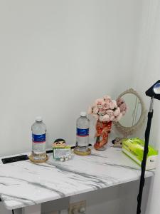 a table with flowers and water bottles on it at Premium Snooze Queen Bed Petite Room in Caroline Springs +16 photos