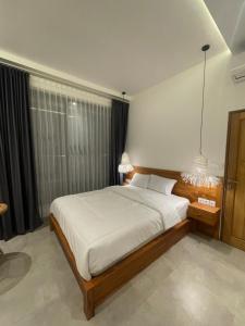 a bedroom with a large bed with white sheets at Puri Gia in Mambat