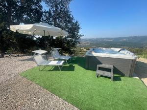 a hot tub and two chairs and an umbrella at Paradise Rooms in Ripabottoni