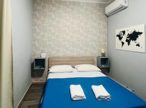 a bedroom with a blue bed with two towels at Il Galileo Rooms in Pisa