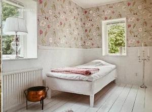 a bedroom with a bed with floral wallpaper at Paradvåning med havsutsikt i fyra etage på 178kvm för 7p in Visby