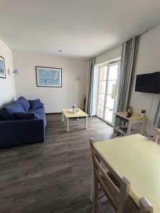 a living room with a blue couch and a table at residence cap ocean ARZON in Arzon