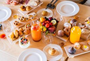a table topped with plates of food and orange juice at Bahal dell'Etna Agri-Resort in Ramacca +14 photos