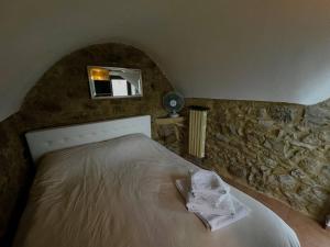 a bedroom with a bed with a stone wall at Villa di campagna con vista mare Sanremo in Pampara