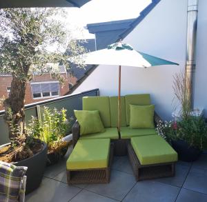 a patio with a chair and an umbrella at Ferienwohnung mit Rheinblick in Kalkar