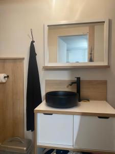 a kitchen with a sink and a mirror at Petit nid au centre historique de Marvejols in Marvejols