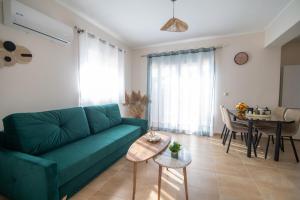 a living room with a green couch and a table at Anthos Residence 1 in Kefalos